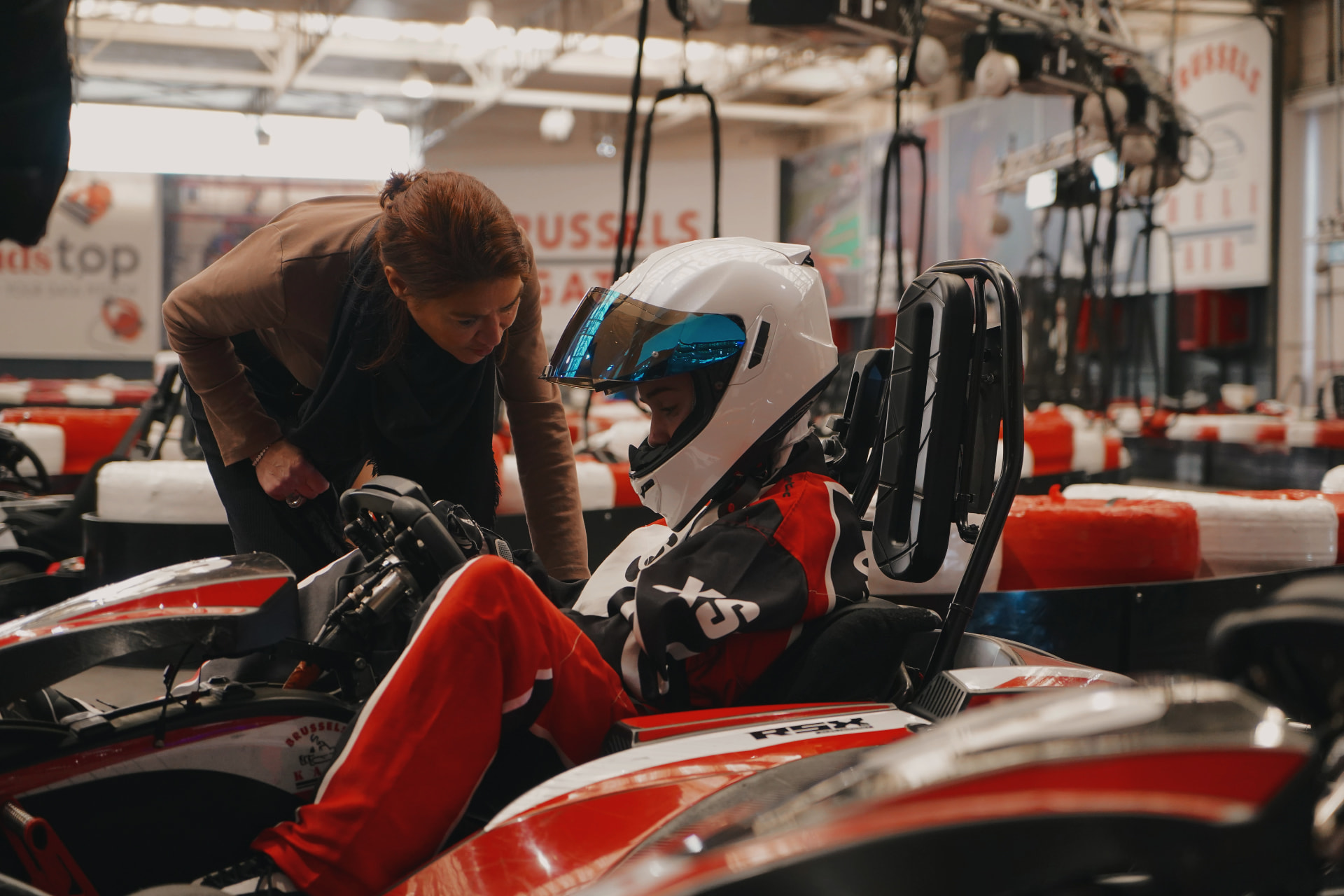 Deux pilotes BYPP en tenue de course se saluant sur un circuit indoor